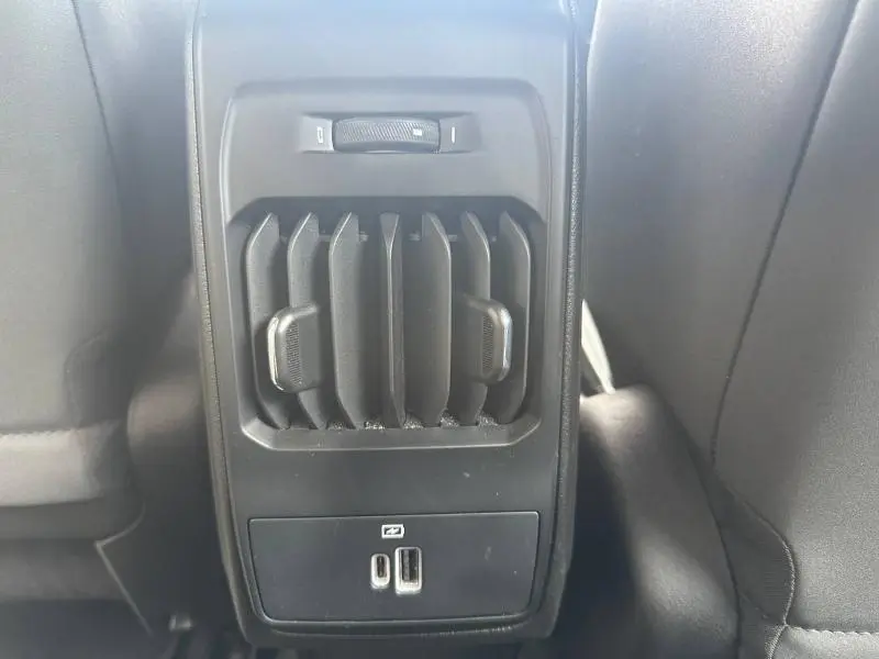Détail de la console arrière noire avec bouches d’aération et ports USB dans l’Alfa Romeo Tonale blanc Monterosa.