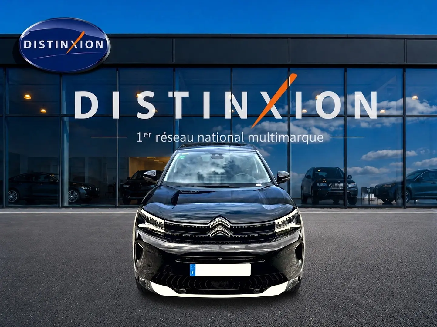 Vue frontale d'un Citroën C5 Aircross hybride rechargeable noir, avec calandre distinctive et phares LED allumés.