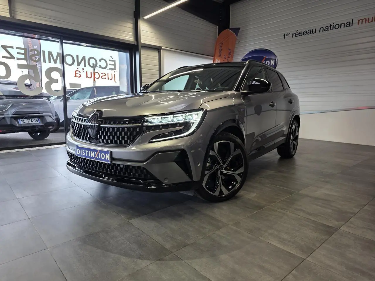Renault Austral gris foncé en 3/4 avant droit, avec calandre damier ice black et jantes alliage 20 pouces Daytona.