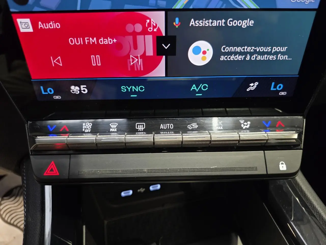 Gros plan sur la console centrale du Renault Austral gris foncé, avec commandes climatisation et écran tactile visible.