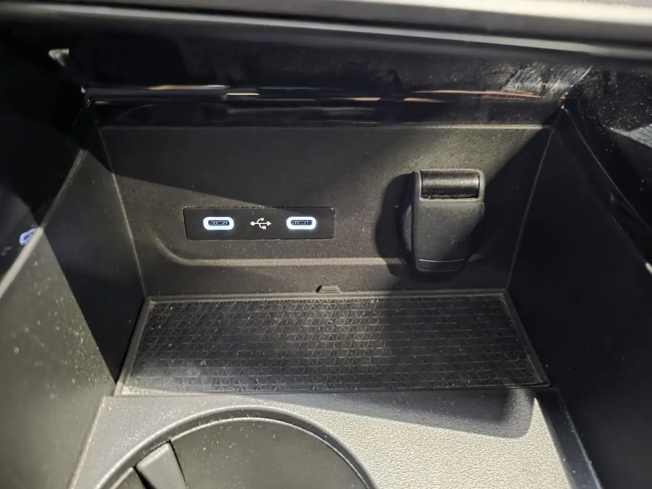 Gros plan sur la console centrale du Renault Austral 2024, montrant deux ports USB et une prise 12V dans un compartiment noir.