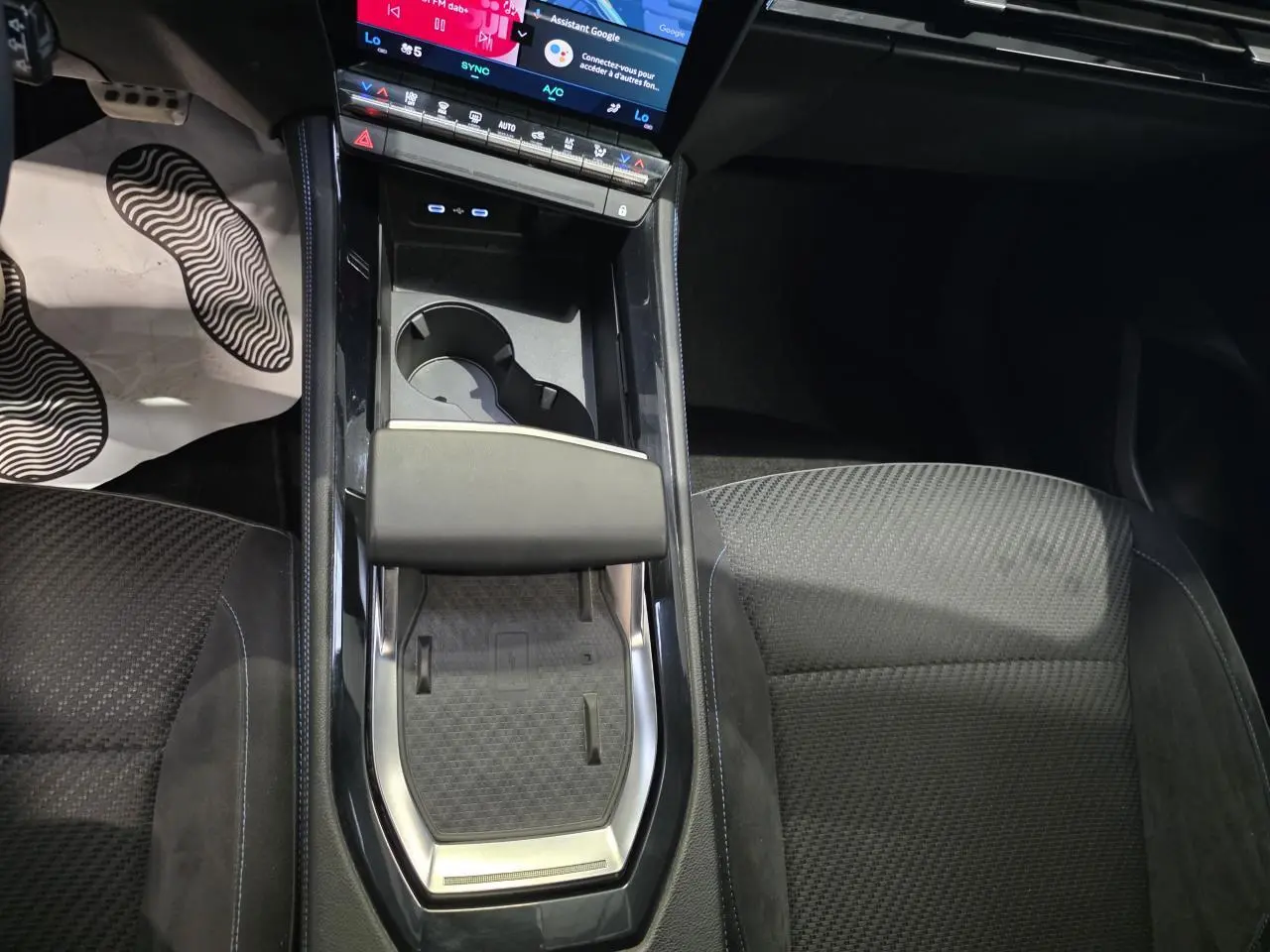 Vue plongeante sur la console centrale du Renault Austral 2024, avec chargeur induction et sellerie tissu Alcantra noire.