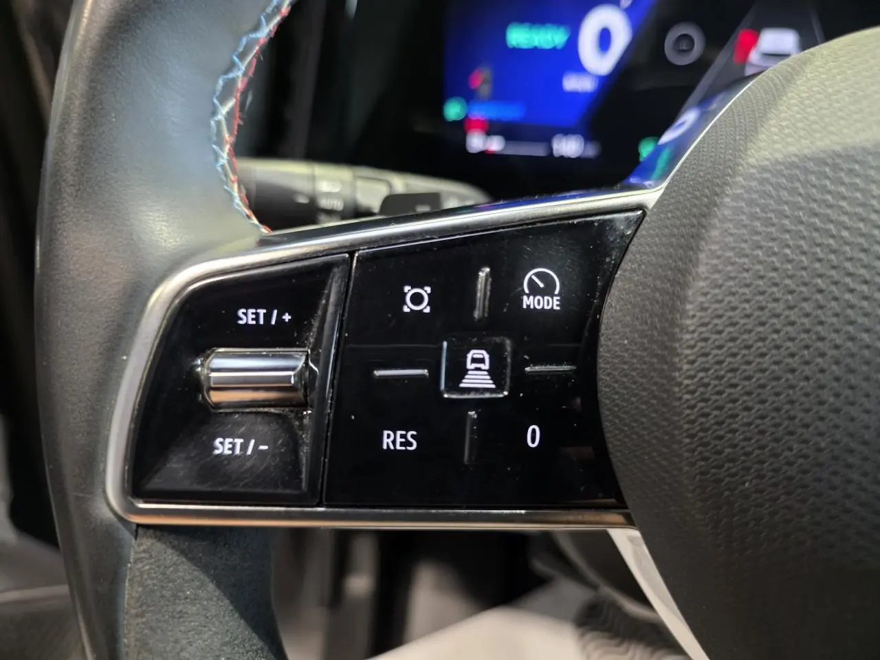 Gros plan sur les commandes gauche du volant textile avec insert Alcantara du Renault Austral gris foncé 2024.