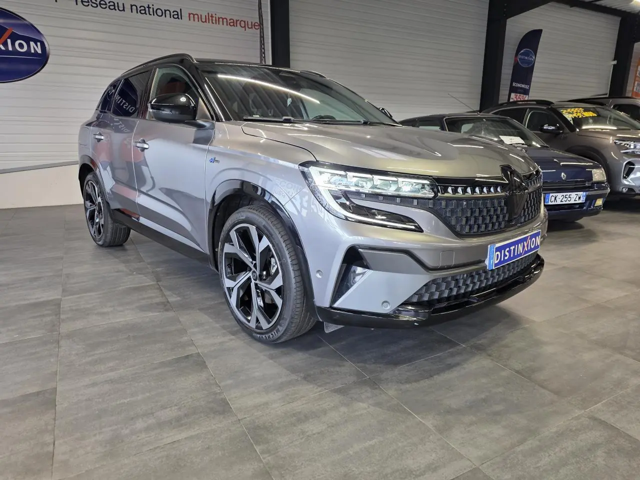 Renault Austral gris foncé en 3/4 avant droit, avec calandre damier ice black et jantes alliage 20 pouces.