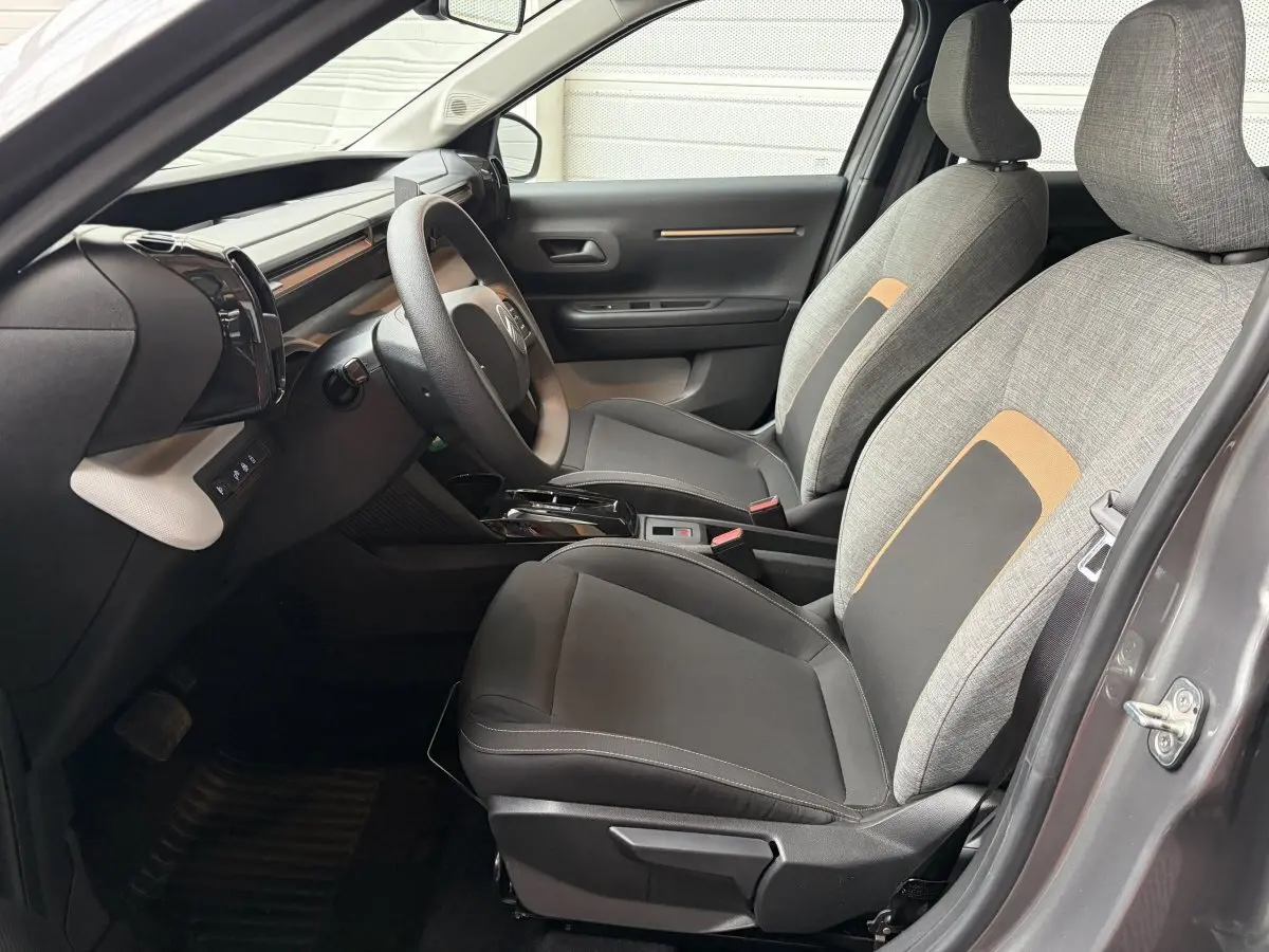 Vue intérieure côté conducteur de la Citroën C3 Aircross 2025 gris foncé, sièges tissu gris et noir avec détails beige.