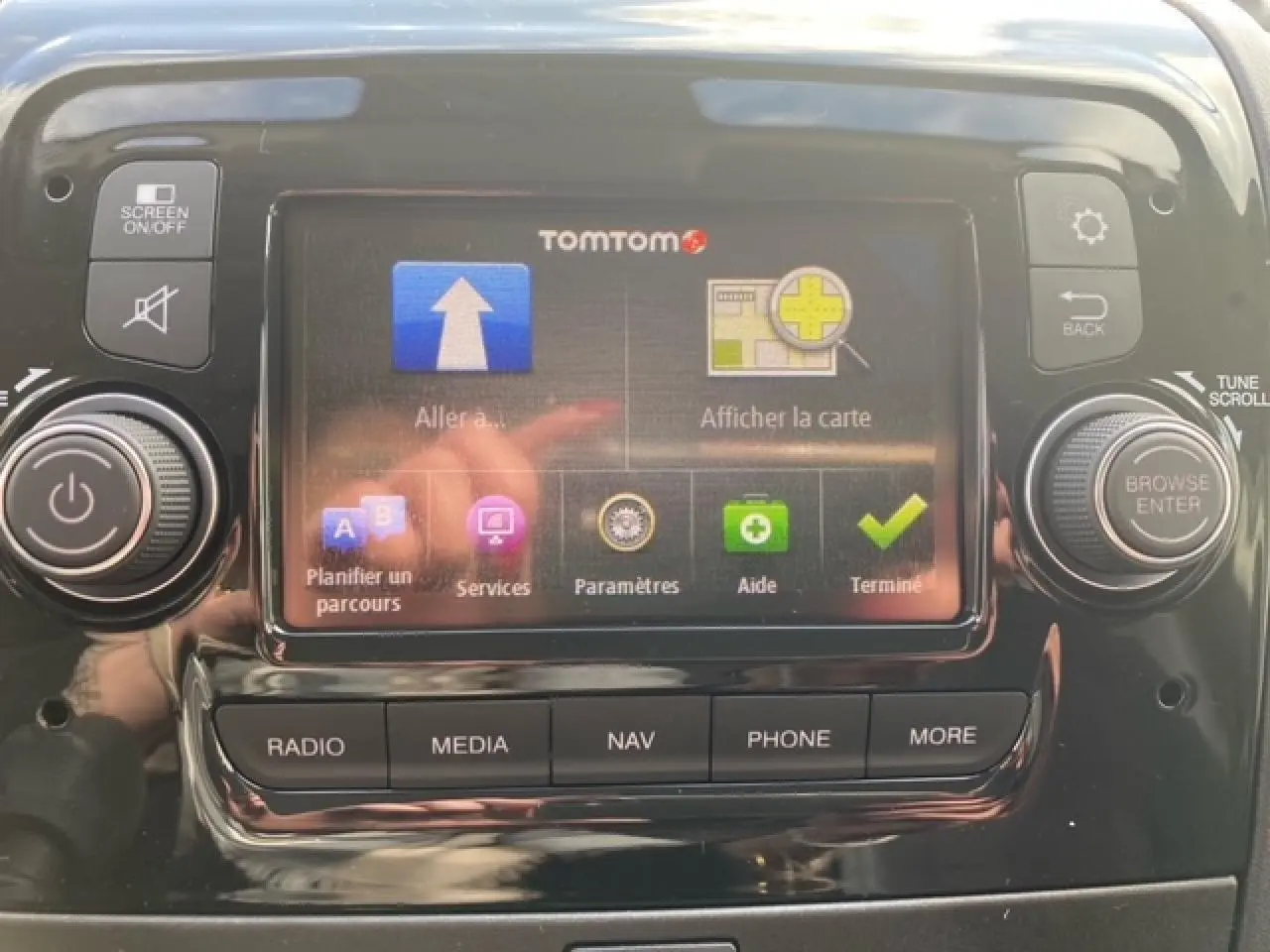 Écran tactile central du système de navigation TomTom dans l'habitacle d'un Opel Movano blanc, avec commandes autour.