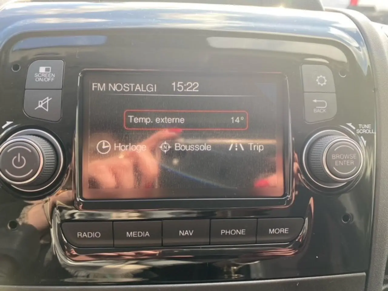 Écran tactile central du tableau de bord de l'Opel Movano Fourgon 2023 affichant la radio FM et la température externe.