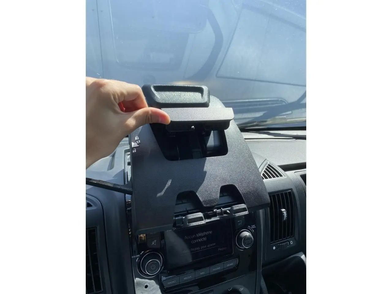 Intérieur de l'Opel Movano Fourgon 2023 montrant le support téléphone au-dessus de la console centrale noire.