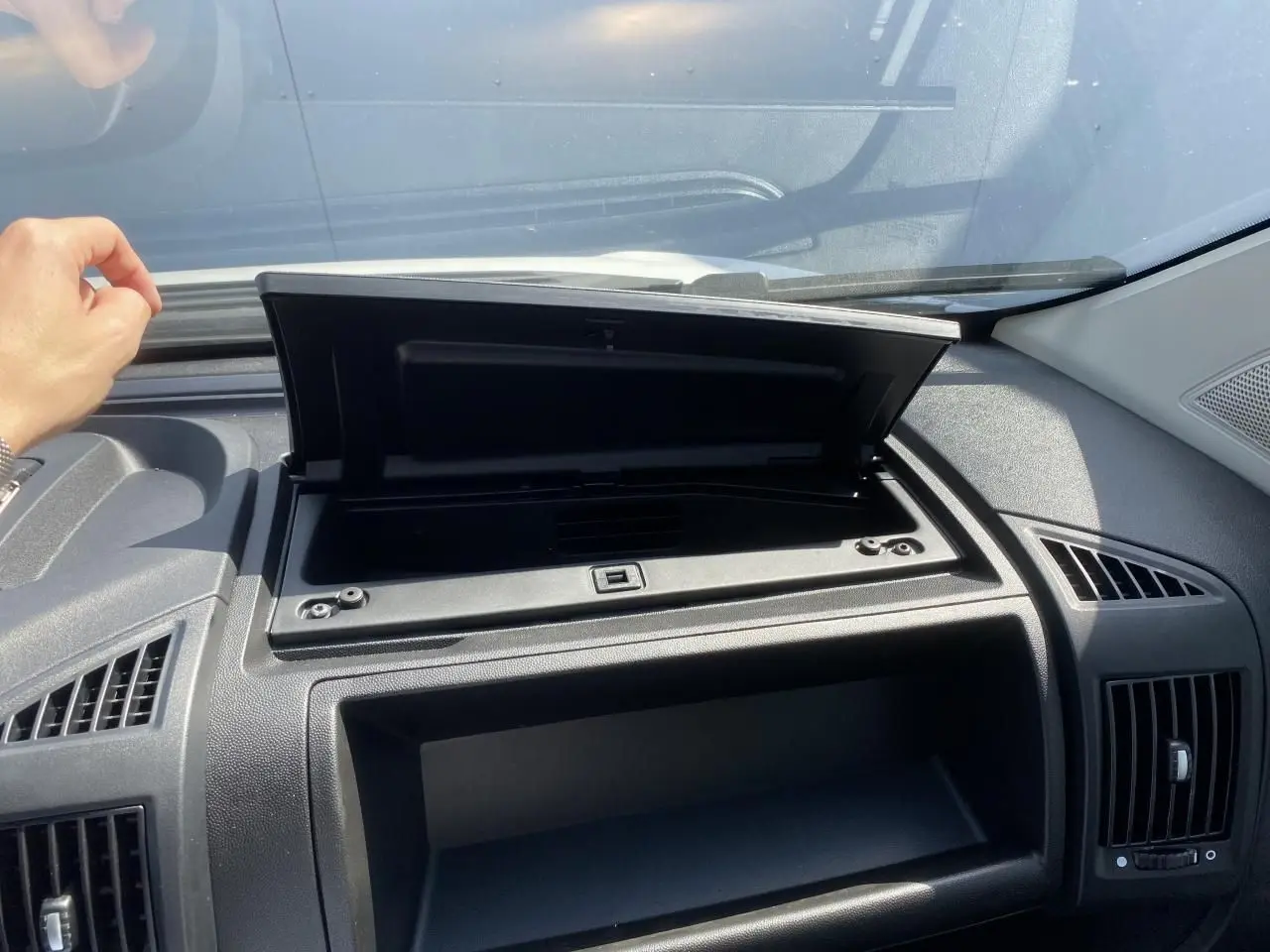 Intérieur du tableau de bord noir de l'Opel Movano Fourgon blanc 2023 avec boîte à gants ouverte côté passager.