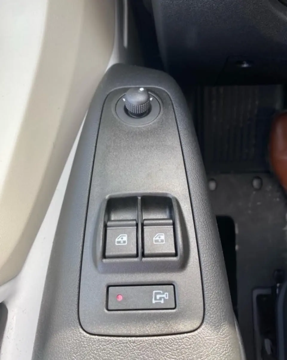 Gros plan sur les commandes de vitres électriques et réglage des rétroviseurs côté conducteur de l'Opel Movano Fourgon blanc 2023.