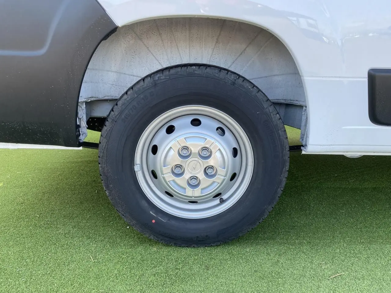 Gros plan sur la roue avant gauche en acier du fourgon blanc Opel Movano 2023, avec logo Opel au centre.