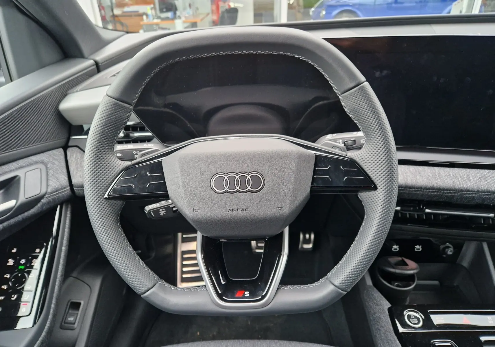 Vue rapprochée du volant multifonction noir avec logo Audi et badge S de l'Audi Q6 e-tron Performance S-Line 2025.