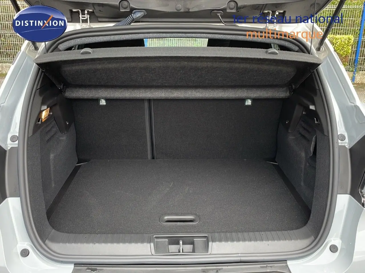 Coffre ouvert d'un Renault Captur gris Rafale métal, vue arrière montrant l'espace de chargement et la tablette cache-bagages.