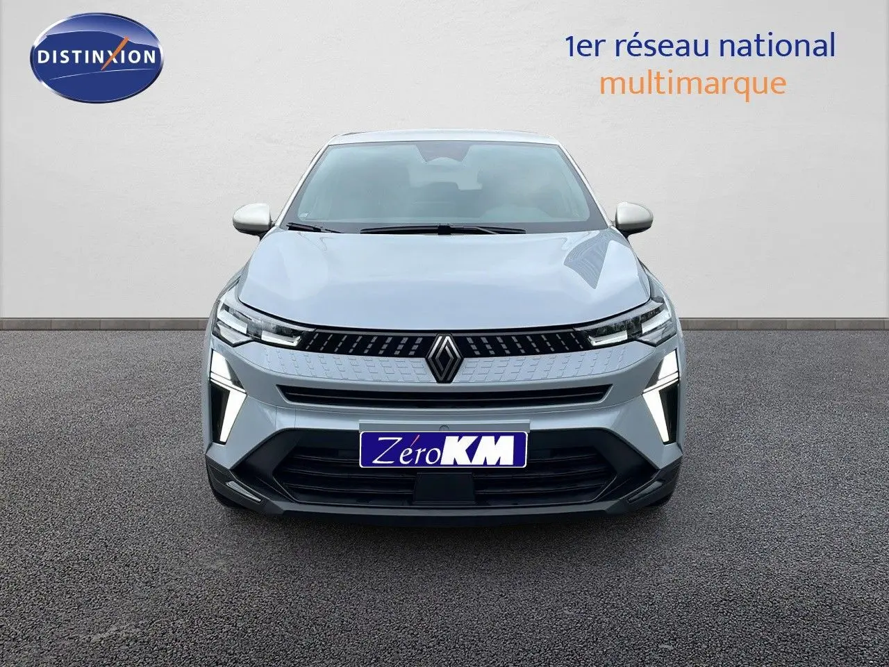 Vue frontale d'un Renault Captur gris Rafale métal avec calandre noire et feux LED allumés sur fond neutre.