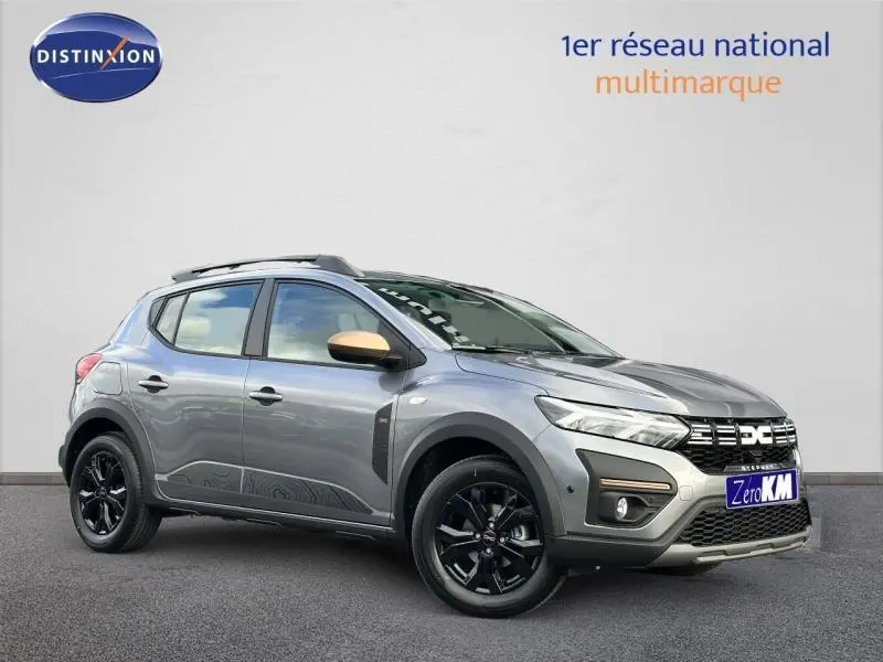 Dacia Sandero Stepway 2025 gris schiste métallisé en 3/4 avant droit avec jantes noires et coques de rétroviseur bronze.