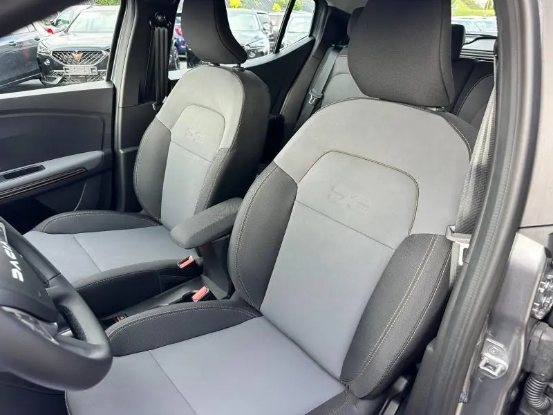 Gros plan sur les sièges avant gris clair et foncé du Dacia Sandero Stepway Extreme 2025, avec logo DS embossé.