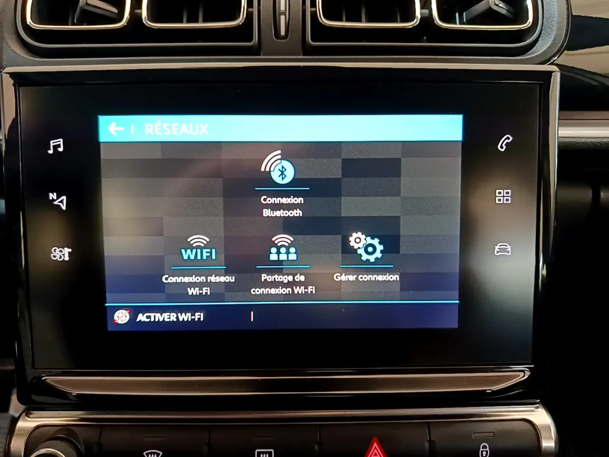 Écran tactile central affichant les options réseau Wi-Fi et Bluetooth dans le tableau de bord d'une Citroën C3 blanche.