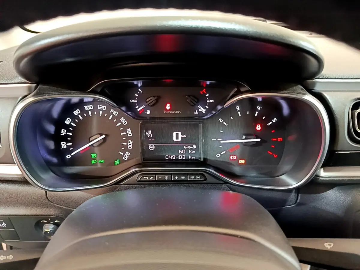 Tableau de bord de Citroën C3 blanc 2019 vu de face, affichage digital et compteurs analogiques éclairés.