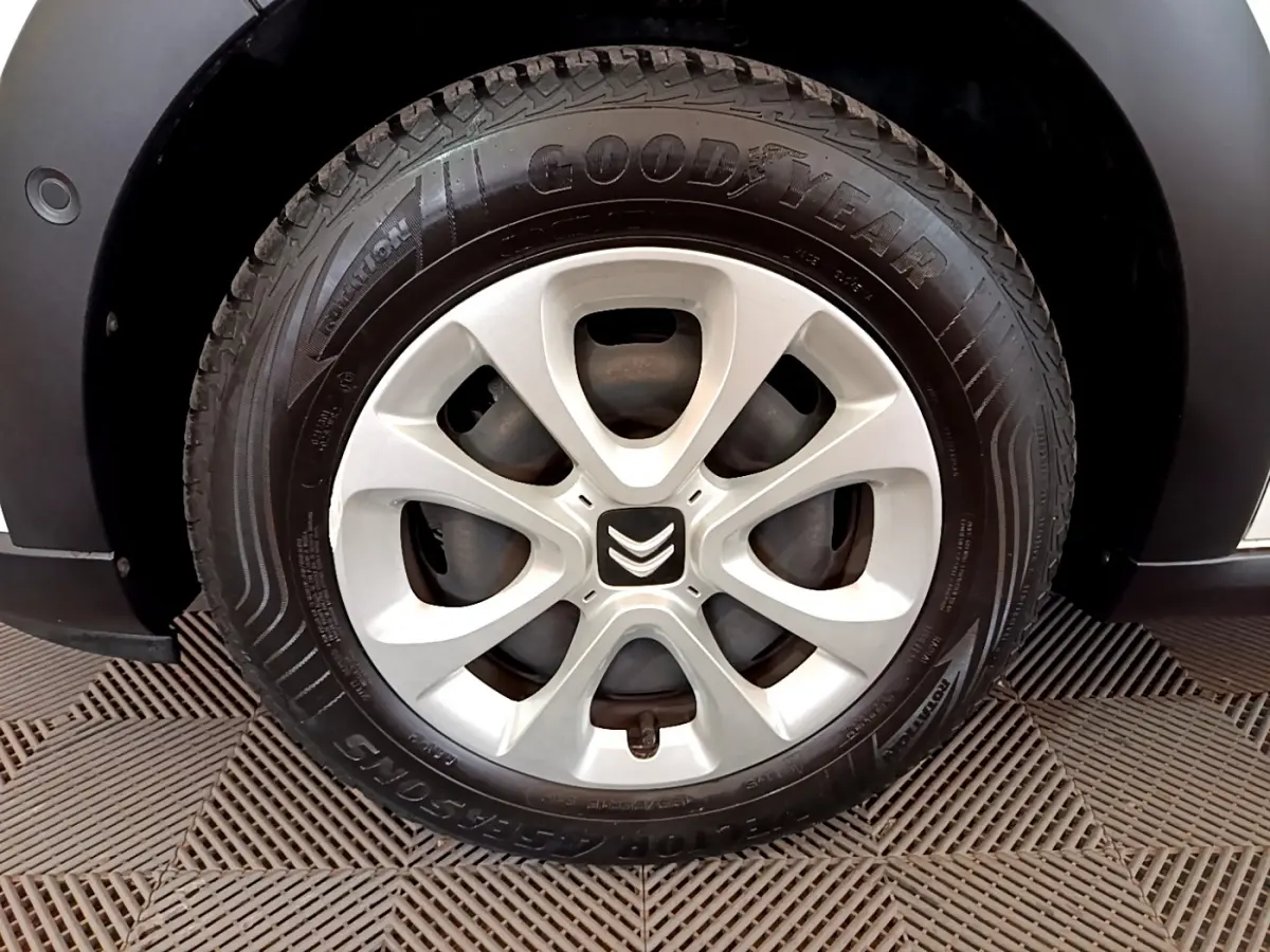 Gros plan sur la roue avant gauche de la Citroën C3 blanche, avec jante alliage et pneu Goodyear visible.