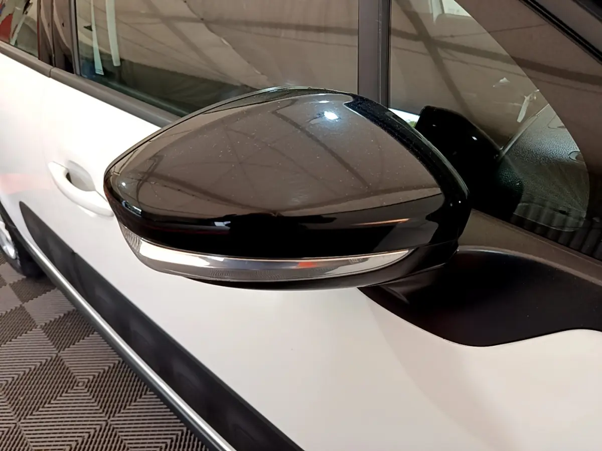 Rétroviseur noir avec clignotant intégré côté droit sur une Citroën C3 blanche vue de profil rapproché.