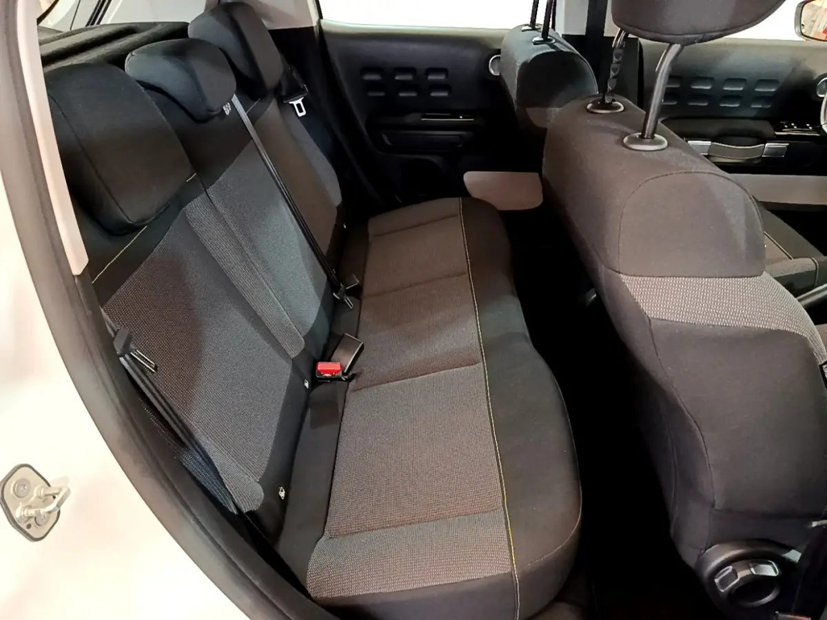 Vue intérieure côté gauche des sièges arrière noirs et gris de la Citroën C3 blanche de 2019.