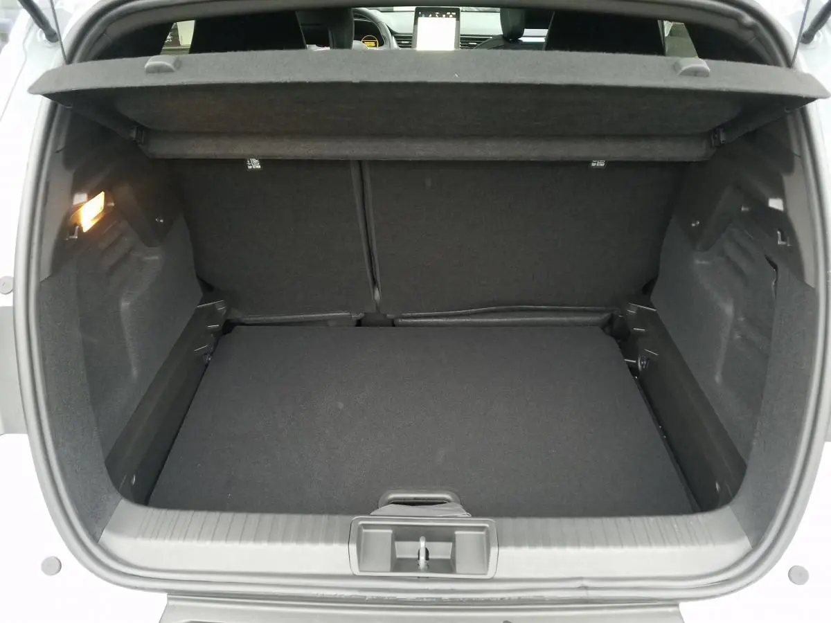 Coffre ouvert vu de l'arrière d'un Renault Captur gris Rafale, montrant l'espace de chargement et la tablette arrière.