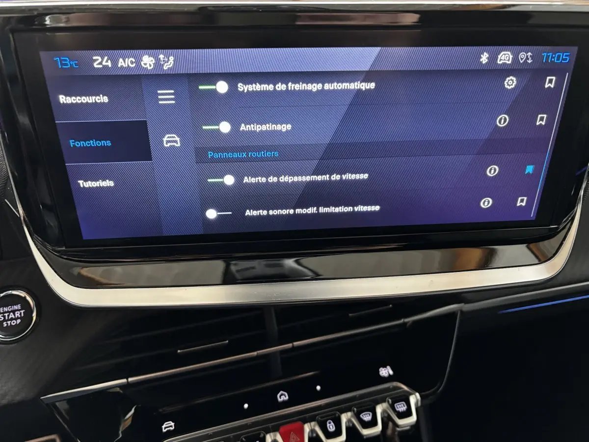 Écran tactile central affichant les réglages d’aide à la conduite dans l’habitacle d’une Peugeot 208 Hybrid gris clair.