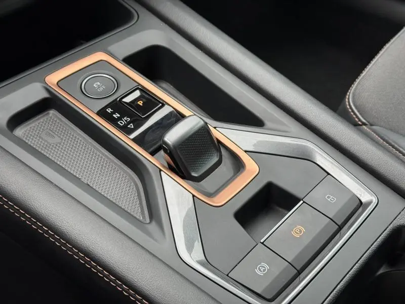 Gros plan sur la console centrale avec levier de vitesse automatique et contour cuivre du CUPRA Formentor bleu 2025.