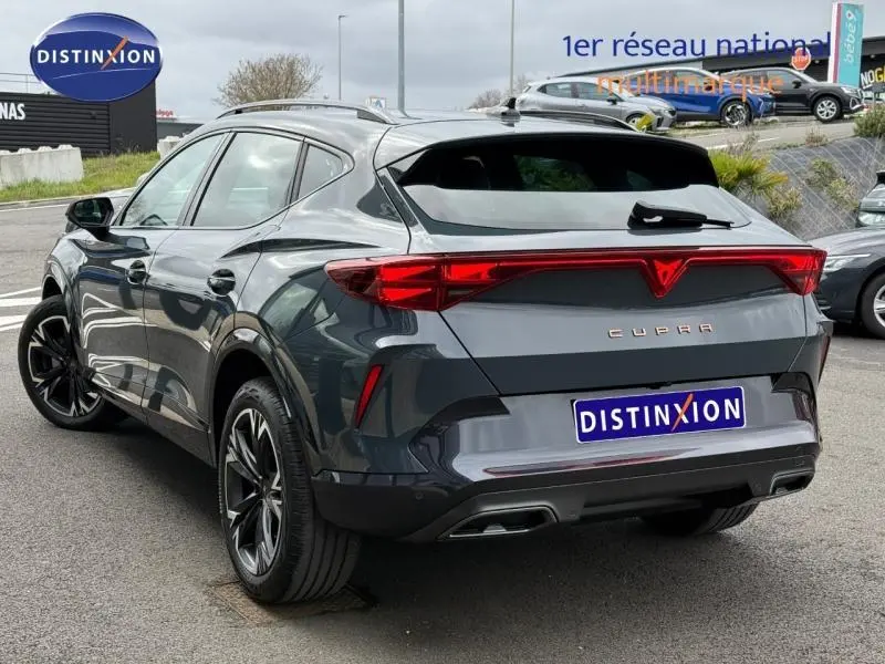 Vue 3/4 arrière droite d'une CUPRA Formentor bleu foncé avec feux arrière LED et double sortie d'échappement.