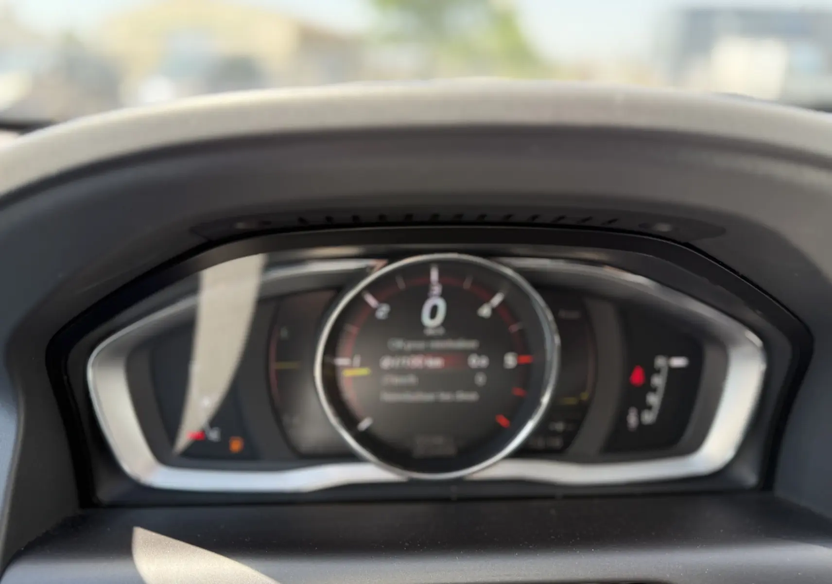 Vue rapprochée du tableau de bord numérique du Volvo XC60 gris foncé, affichant le compteur de vitesse au centre.