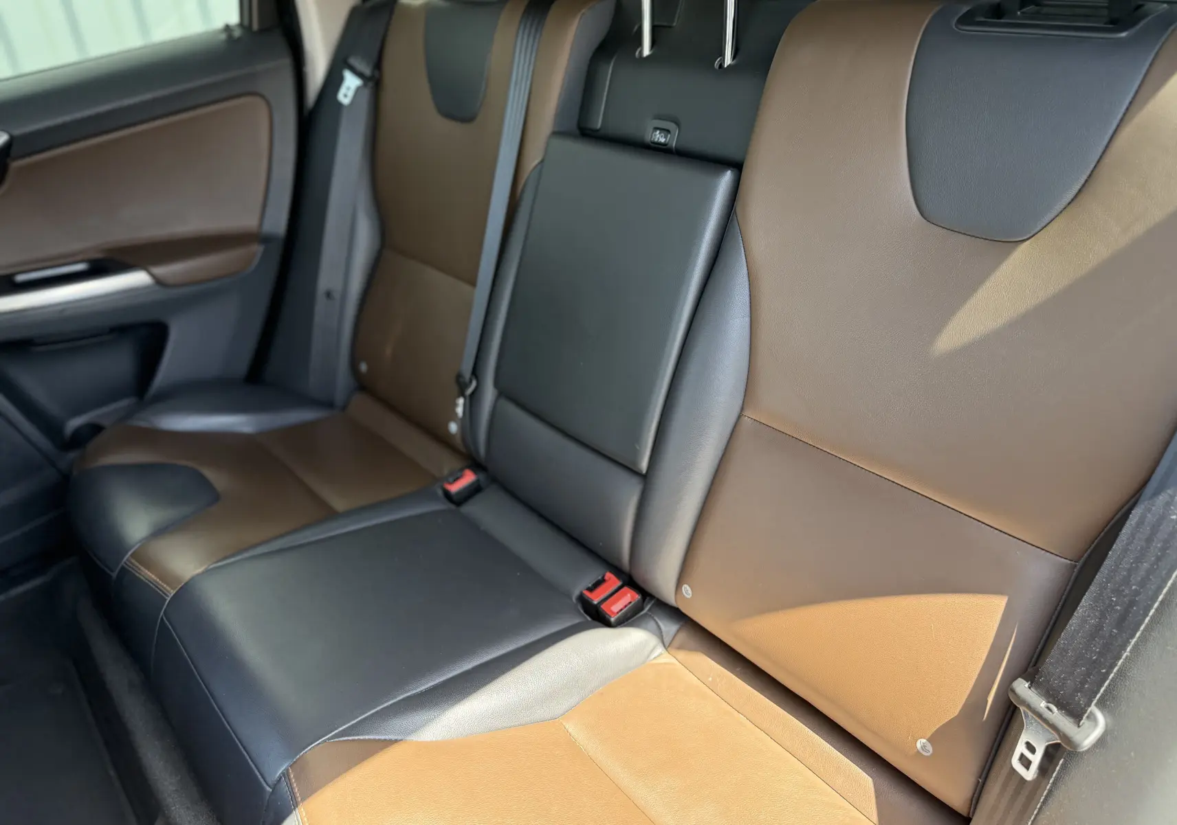 Vue intérieure des sièges arrière en cuir bicolore marron et noir du Volvo XC60 gris foncé, version 2016.