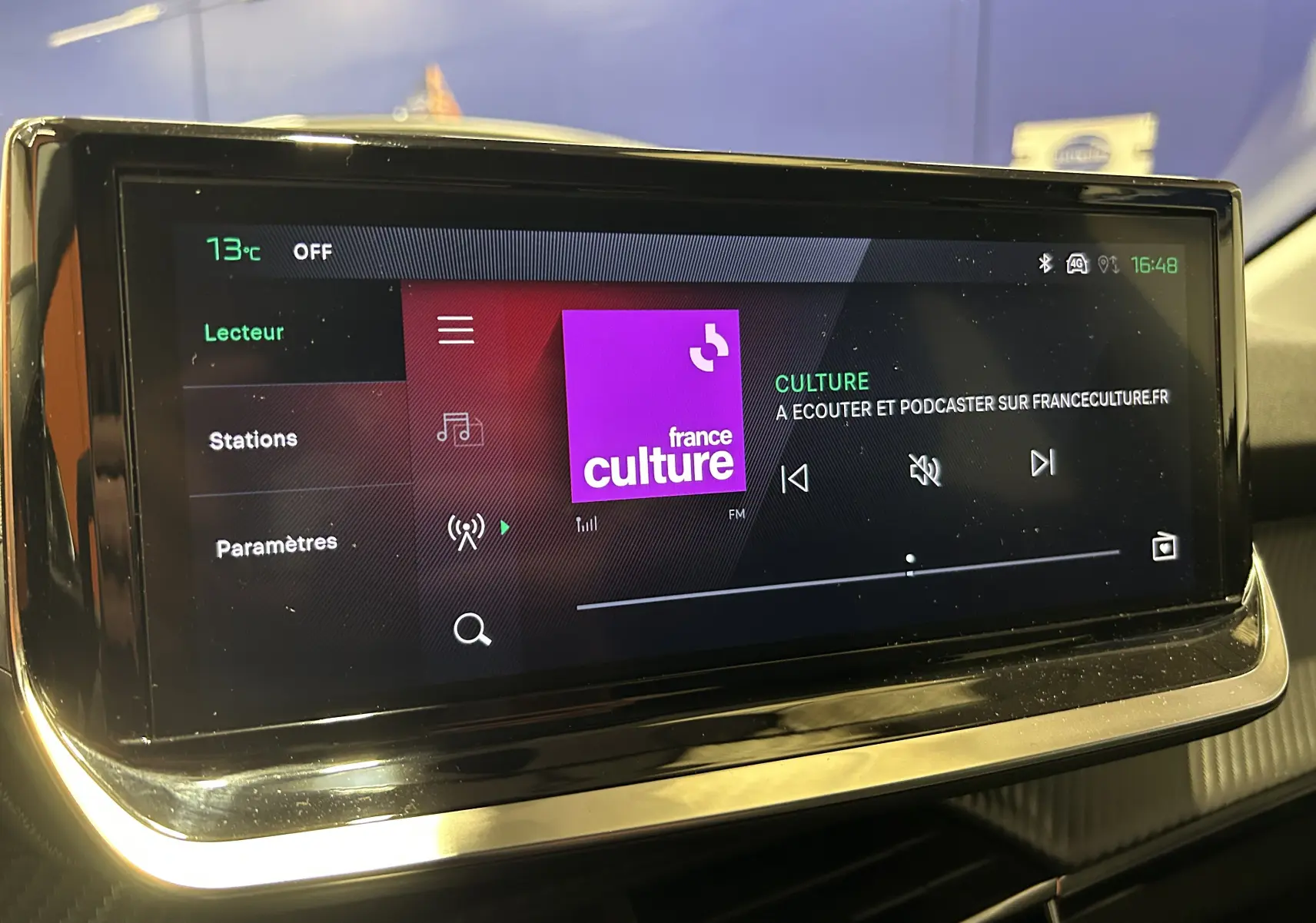 Écran tactile central du Peugeot 208 gris Selenium, affichant la radio France Culture en intérieur.