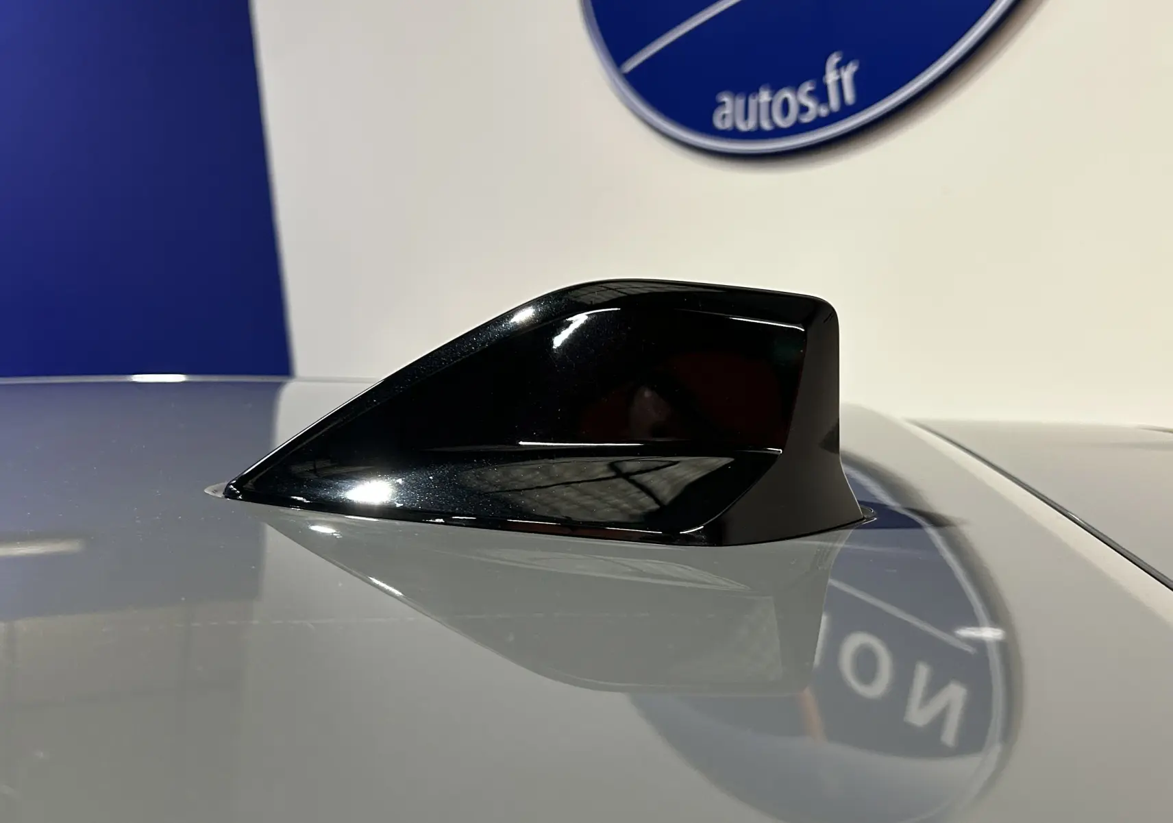 Antenne requin noire en gros plan sur le toit gris Selenium d'une Peugeot 208 II Turbo 100 Allure 2025.