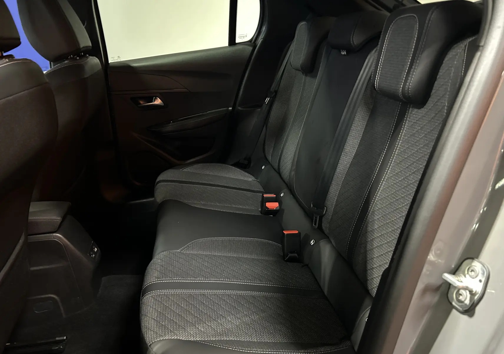 Vue intérieure côté droit des sièges arrière gris foncé de la Peugeot 208 II Turbo 100 Allure 2025 avec porte ouverte.