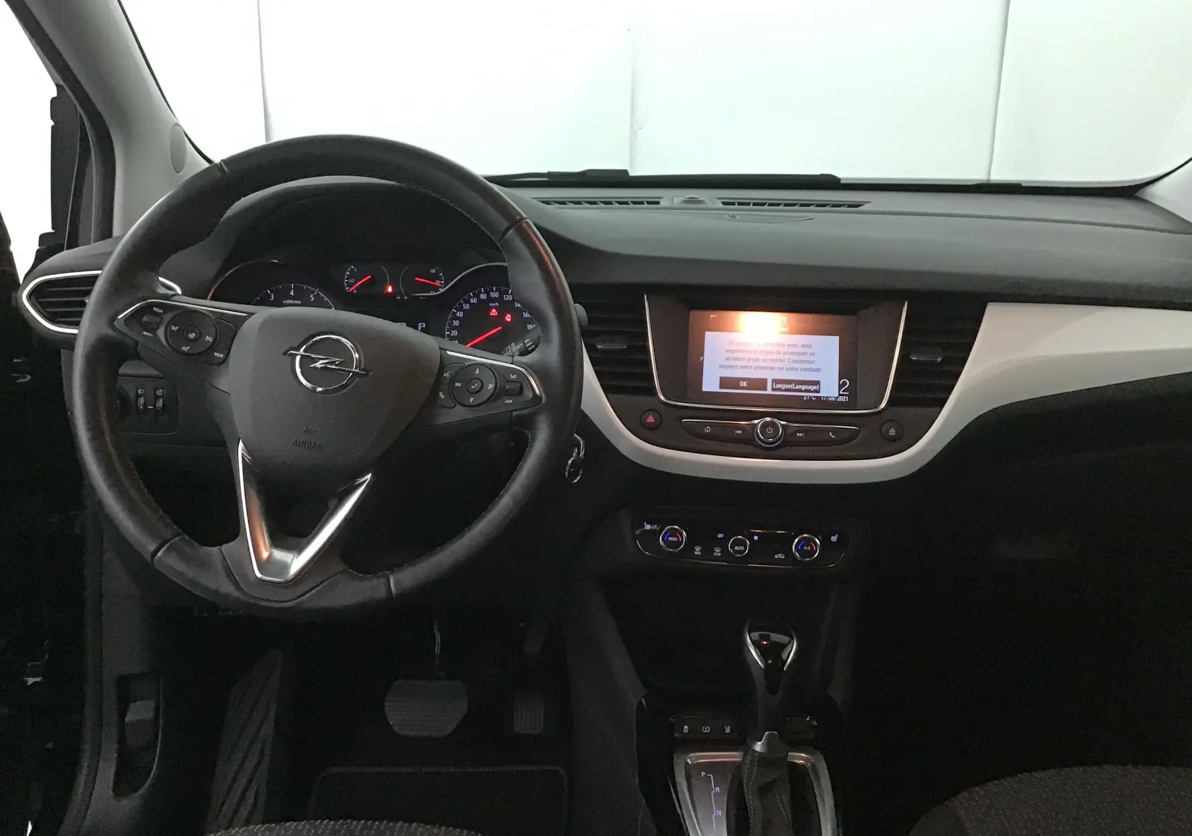 Vue intérieure avant de l'Opel Crossland noir 2022, tableau de bord avec écran central et volant multifonction.