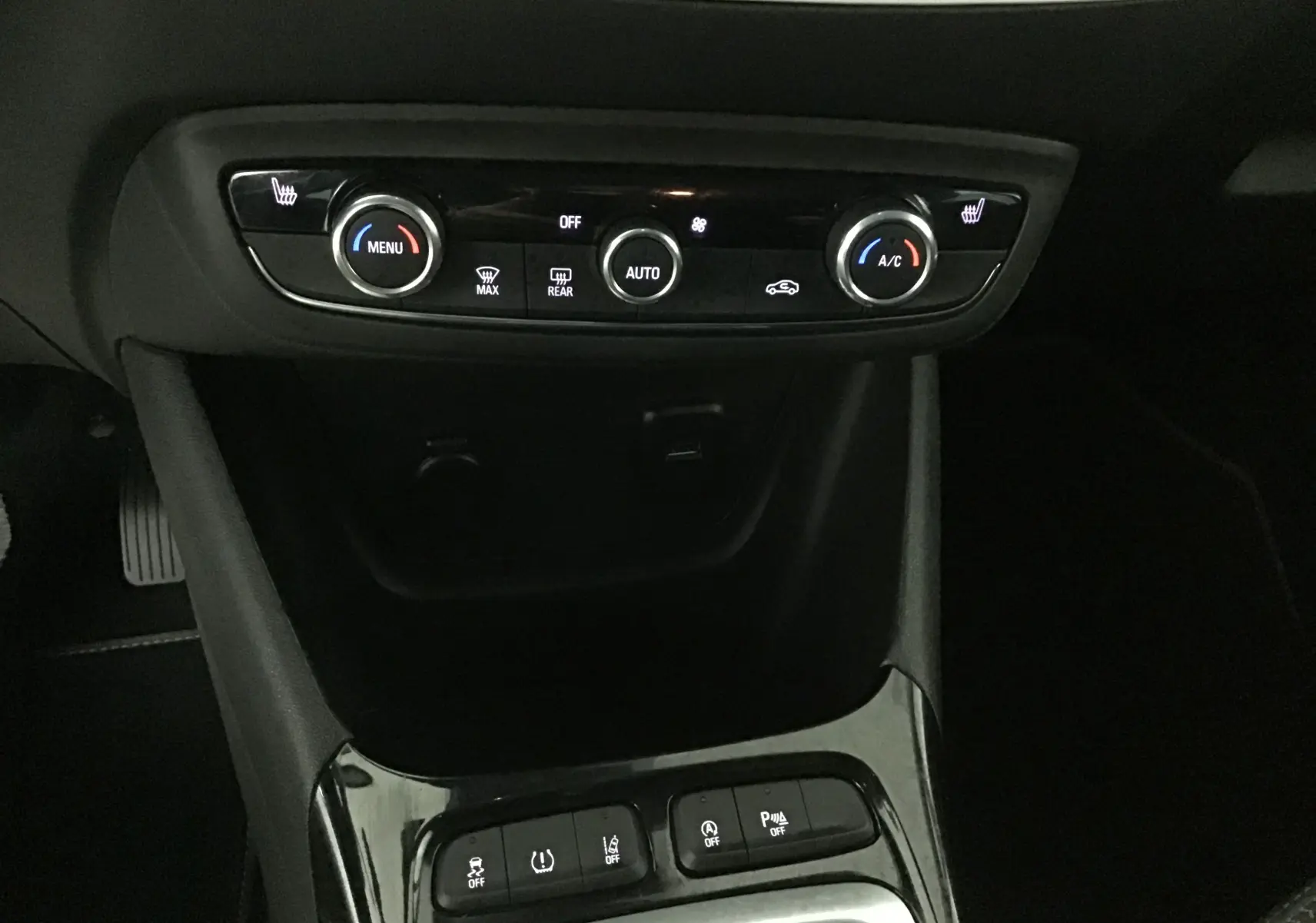 Gros plan sur la console centrale de l'Opel Crossland noire 2022, montrant les commandes de climatisation et les boutons d'assistance.