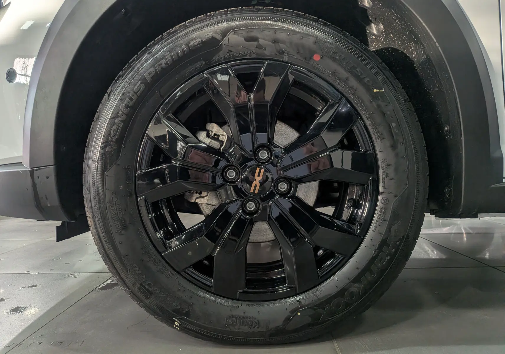 Gros plan sur la roue avant droite noire brillante du Dacia Sandero Stepway blanc glacier 2025.