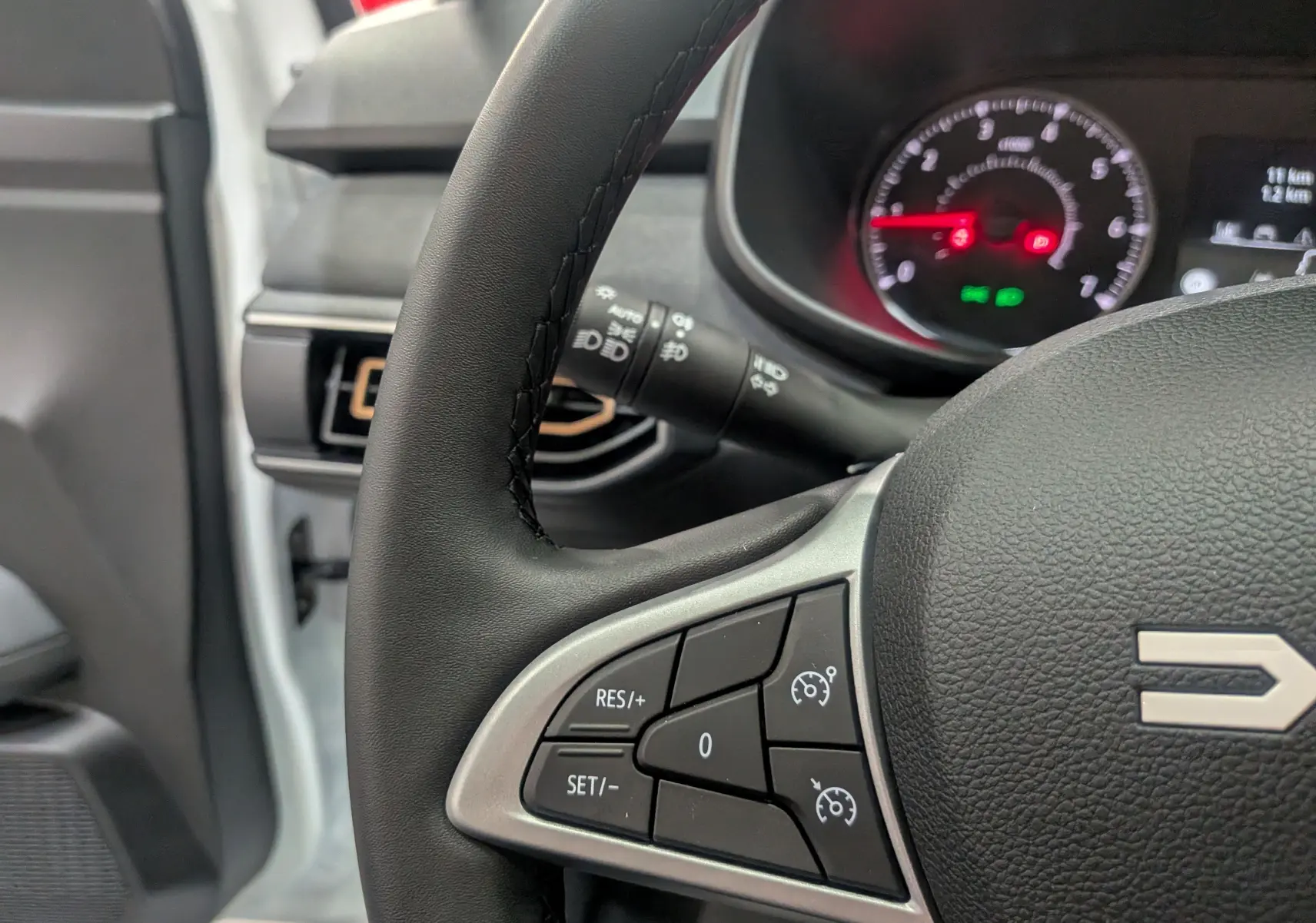 Gros plan sur le volant noir du Dacia Sandero Stepway 2025, montrant les commandes de régulateur de vitesse côté gauche.