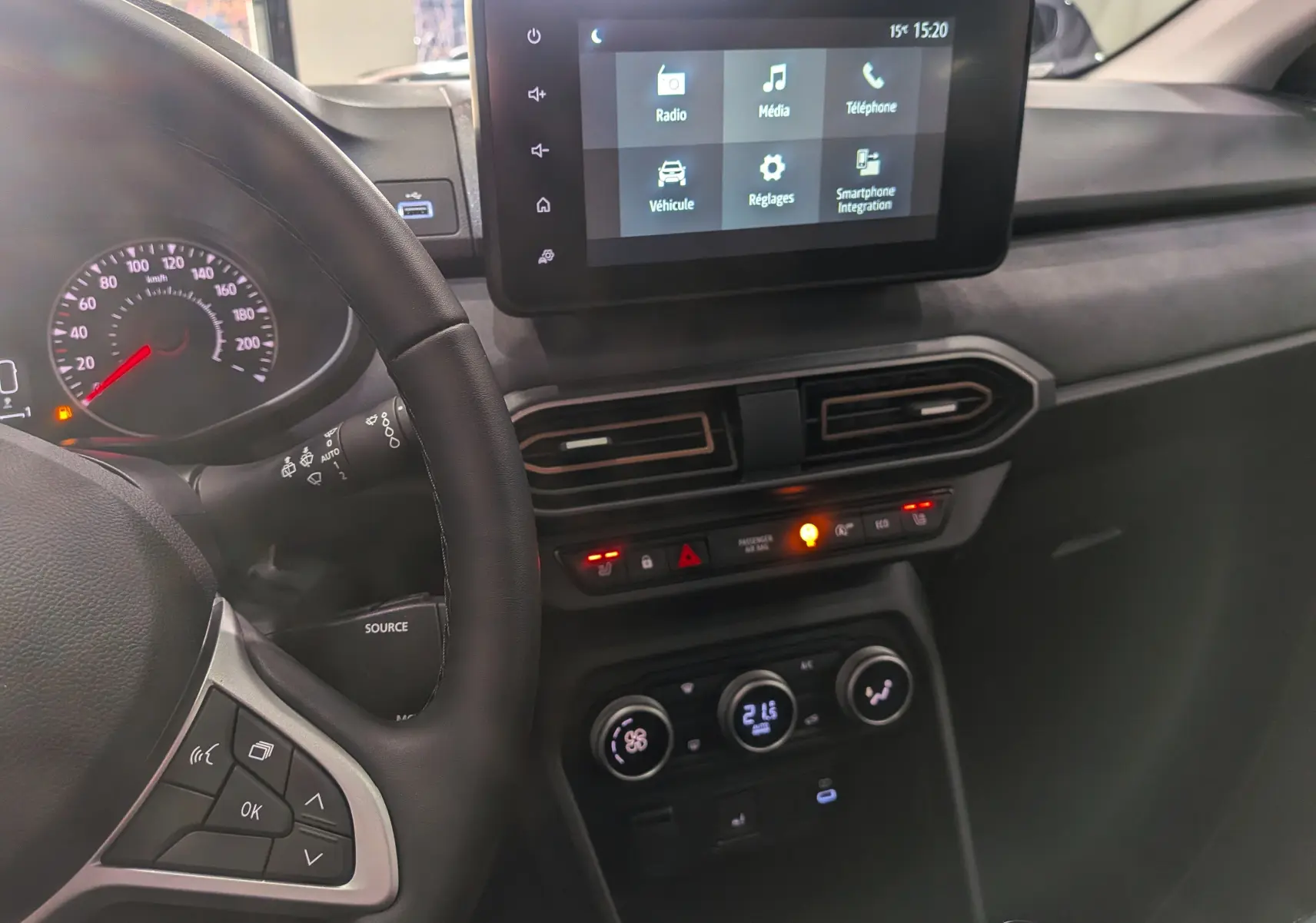 Vue rapprochée de l'intérieur du Dacia Sandero Stepway 2025, tableau de bord avec écran tactile et volant côté gauche.