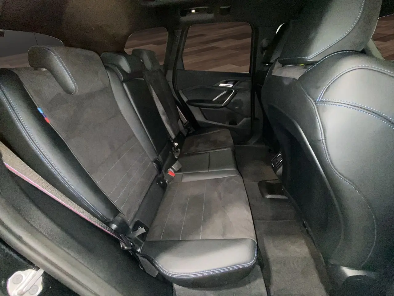 Vue intérieure côté droit des sièges arrière en cuir noir avec surpiqûres bleues du BMW X1 XDRIVE 20D M SPORT 2025.