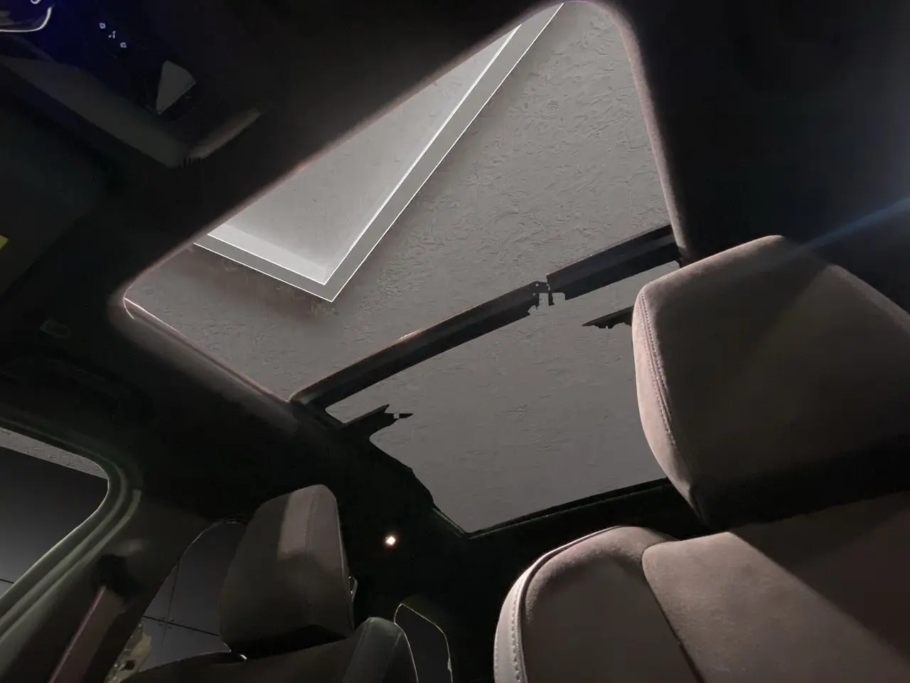 Vue intérieure du toit ouvrant panoramique du BMW X1 XDRIVE 20D M SPORT BVA noir, mettant en valeur les sièges avant en tissu.