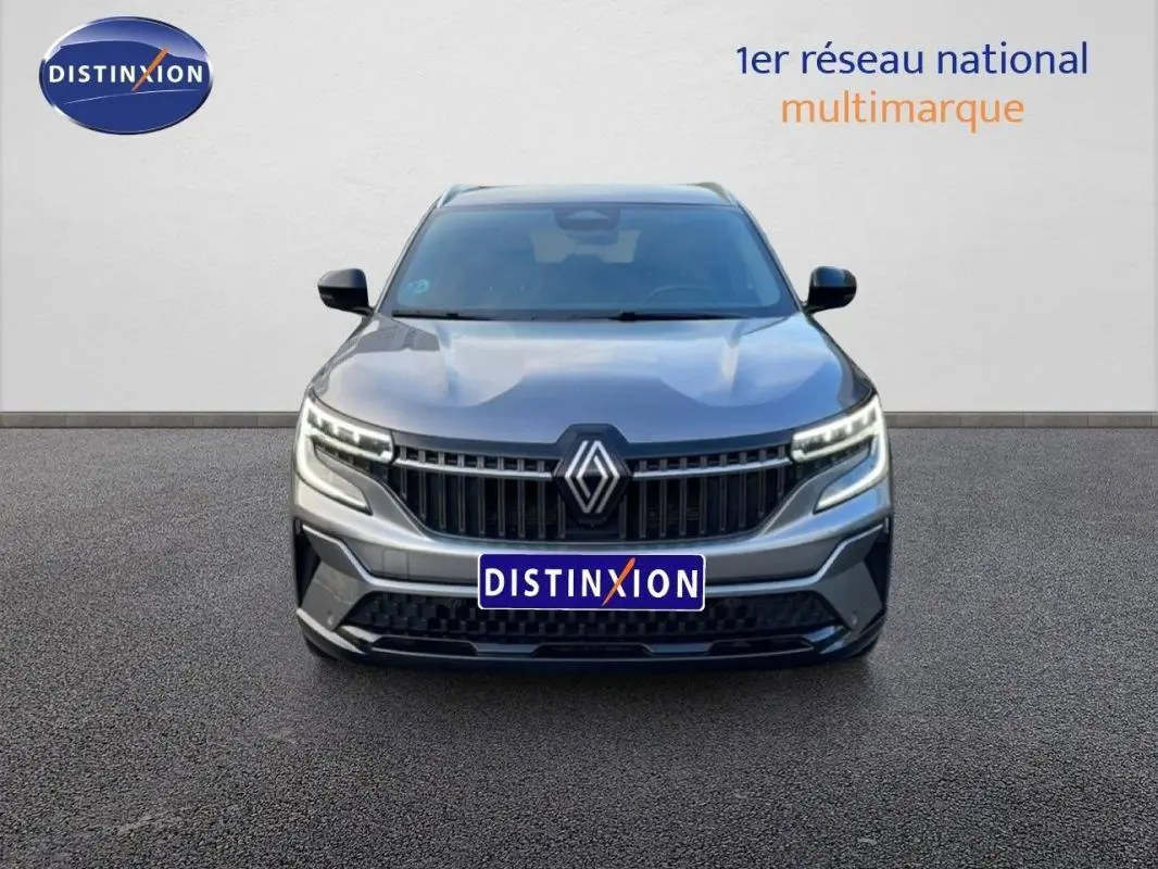 Vue frontale d'un Renault Espace gris 2024 avec calandre noire et feux LED distinctifs allumés.
