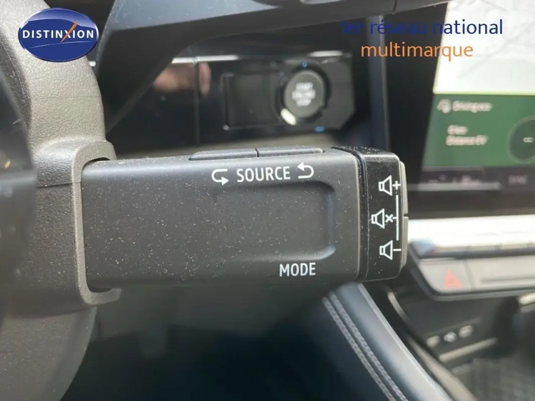 Gros plan sur la commande au volant du Renault Espace gris 2024, avec écran tactile et affichage numérique en arrière-plan.