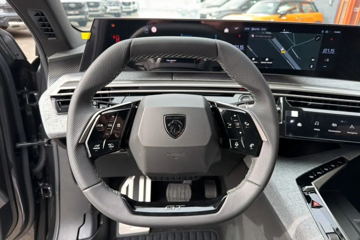 Vue rapprochée du volant cuir multifonctions Peugeot 3008 Hybrid GT avec tableau de bord numérique et finitions Alcantara.