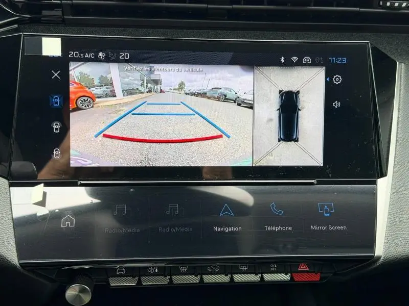 Écran tactile de la Peugeot 308 Hybrid blanc montrant la caméra de recul et la vue 360° du véhicule en stationnement.