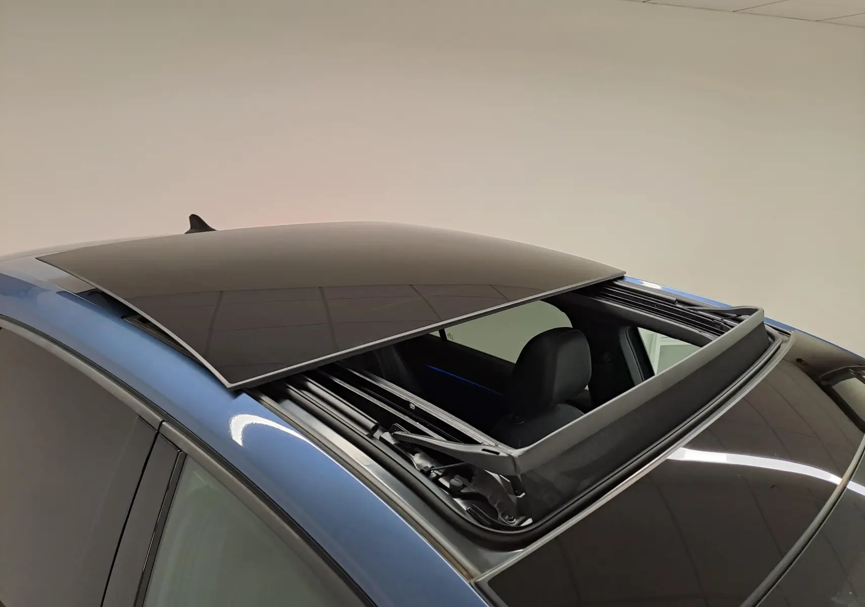 Vue rapprochée du toit ouvrant panoramique noir sur une Volkswagen Golf 1.5 eTSI Bleu Anémone 2024.