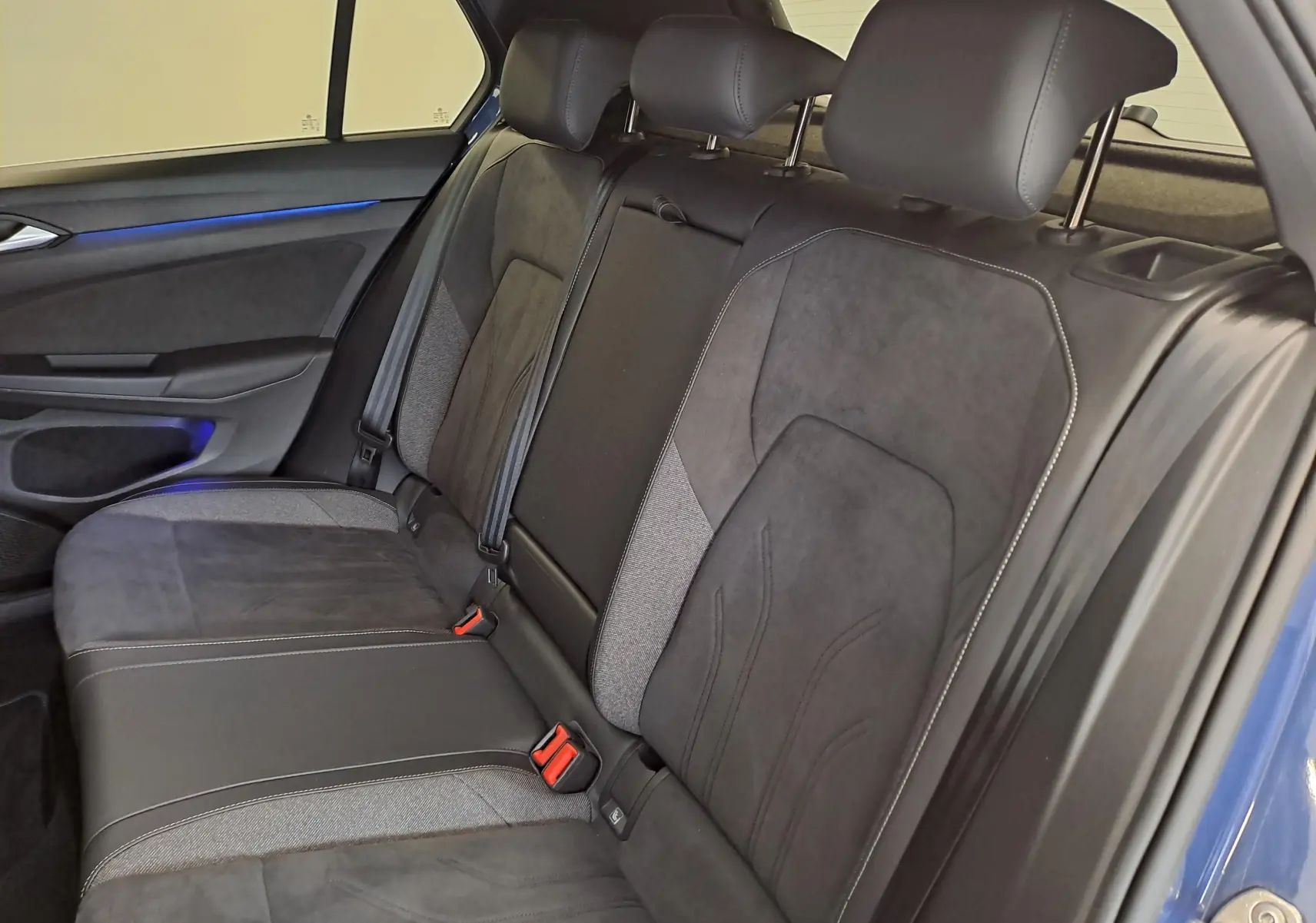 Vue intérieure côté droit des sièges arrière en tissu et alcantara gris foncé de la Volkswagen Golf 1.5 eTSI 150 DSG7 Bleu Anémone 2024.