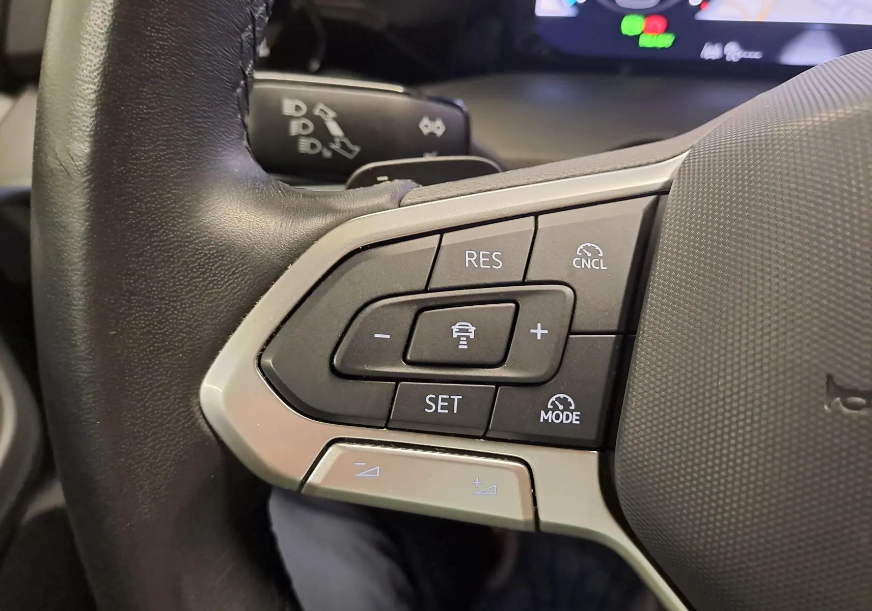 Gros plan sur les commandes de régulateur de vitesse au volant d'une Volkswagen Golf 2024, finition Edition 50.