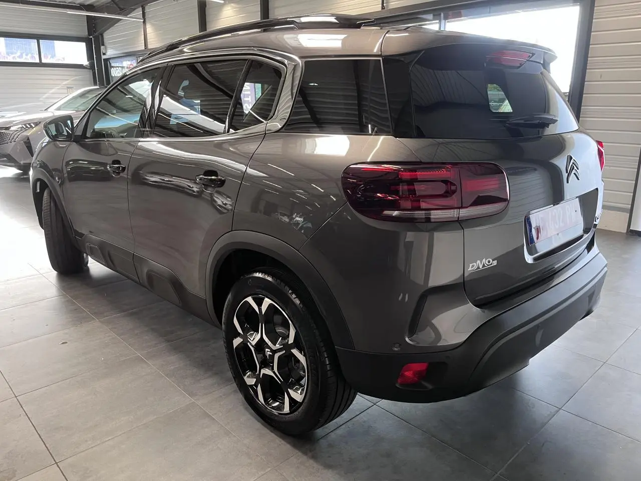 Vue 3/4 arrière droit du Citroën C5 Aircross gris platinium avec jantes alliage bi-ton et vitres teintées.