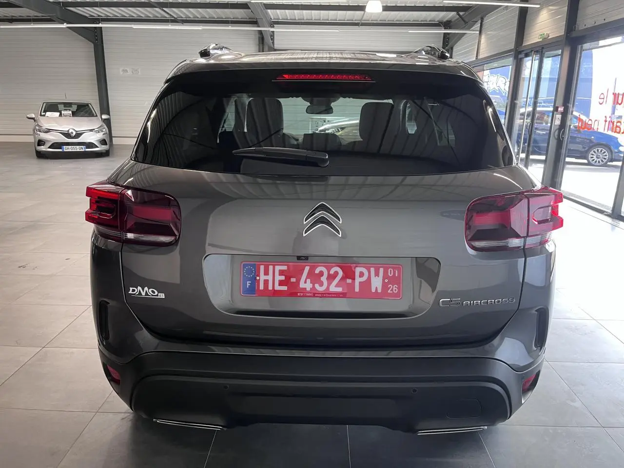 Vue arrière du Citroën C5 Aircross gris platinium avec feux arrière LED et double sortie d'échappement visible en showroom.